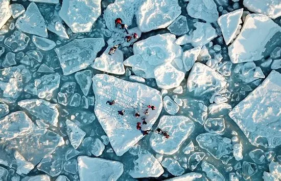 group of people walking on drift ice