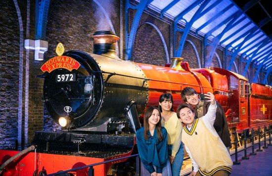 group of people posing in front of hogwarts express