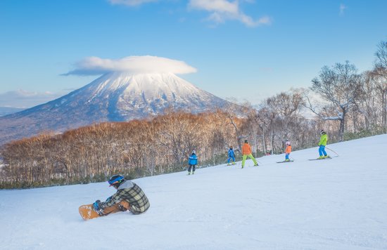 people skiing with mt yotei in the background