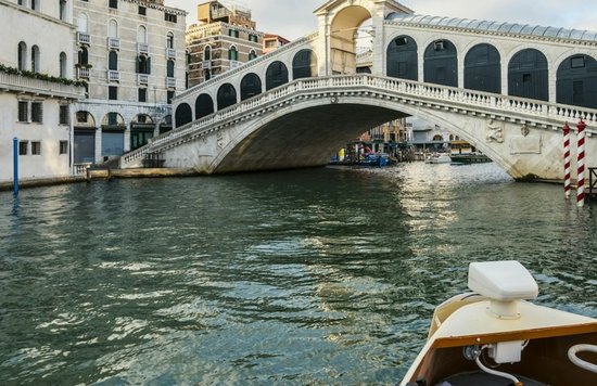 Boat approaching Ponte di Rialto over the Grand Canal in Venice