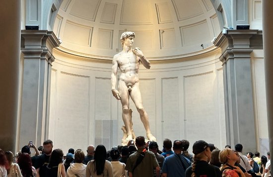 A crowd of people take photos of Michelangelo’s David inside the Galleria dell Accademia Museum in Florence