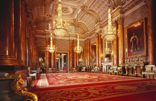 Lavish interior of Buckingham Palace State Rooms with chandeliers and red carpet.