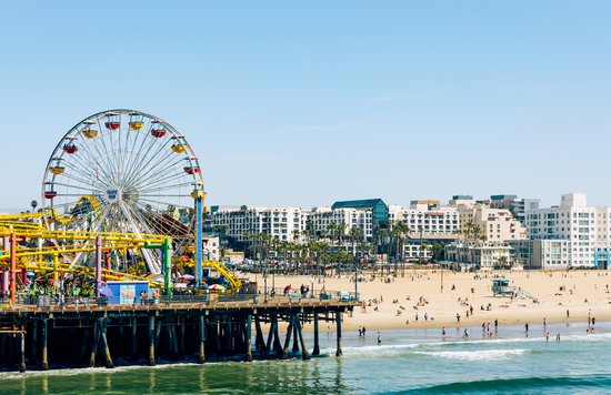 Pacific Park Ferris wheel and Santa Monica Beach on a bright day.
