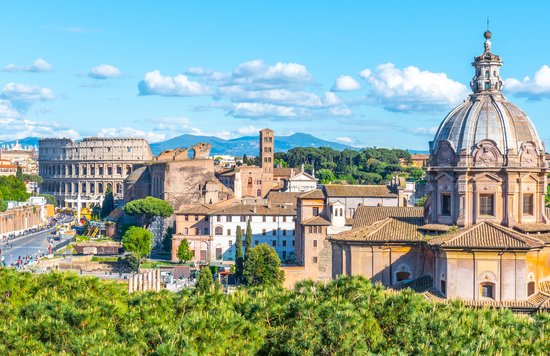 A panoramic view of Rome with the Colosseum and historic buildings under blue skies