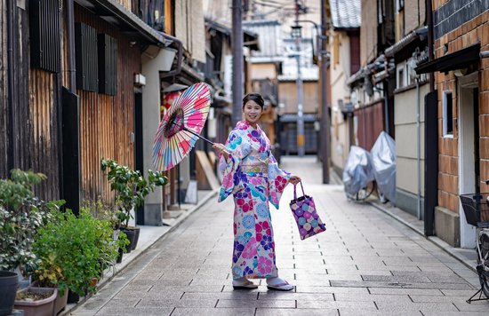 Woman in kimono posing with umbrella on a narrow street in Gion, Kyoto
