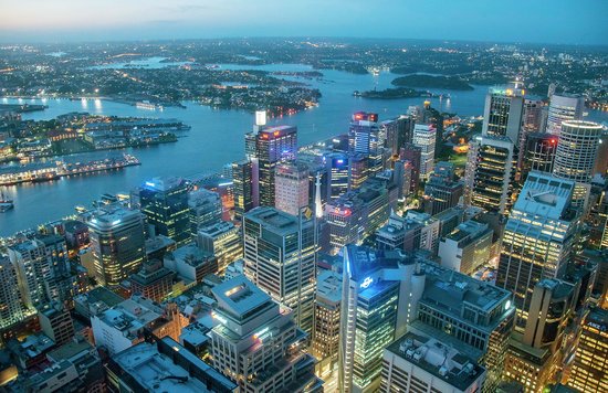 Aerial view of Sydney city skyline at dusk showing harbor, skyscrapers, and city lights
