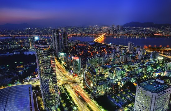 Night view of Seoul city skyline with illuminated buildings and river