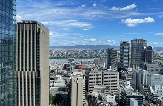Osaka skyline view showing city buildings and river under blue sky