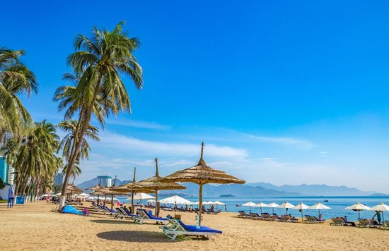 Nha Trang Beach Vietnam showing golden sand, blue sky, and calm waters