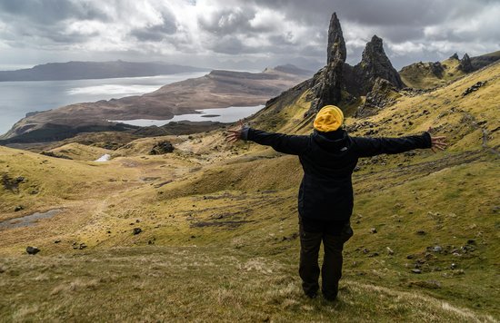  Hiker standing with arms outstretched overlooking the Old Man of Storr on the Isle of Skye | Photo Credit: Gabriela Palai on Pexels