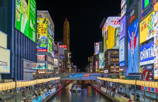 Dotonbori nightlife in Osaka with bright signs, crowds, and canal boats