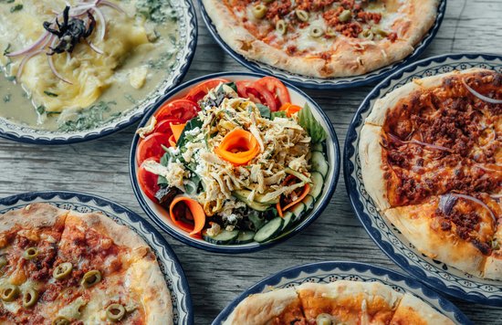 Famous Italian food - Traditional Italian pizza varieties and fresh salad on wooden table
