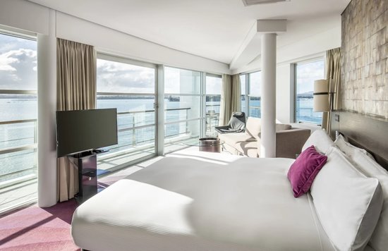 Hilton Auckland guest room overlooking the harbor with floor-to-ceiling windows
