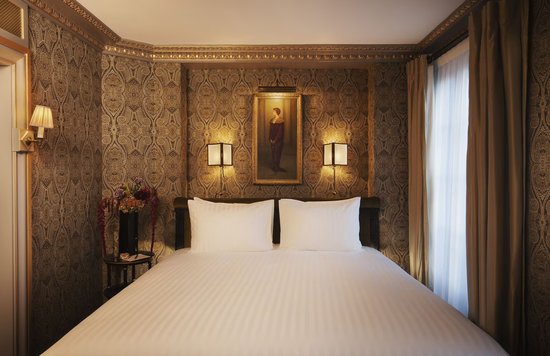 Luxury bedroom at Maison Proust Hotel inspired by Marcel Proust with elegant fabrics and artwork.