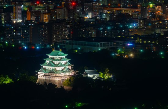 Nagoya Castle as seen at night, with the cityscape in the background.