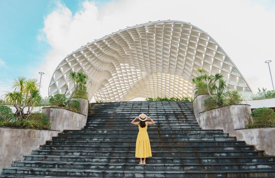 Woman in yellow dress standing at an architectural landmark in Vietnam