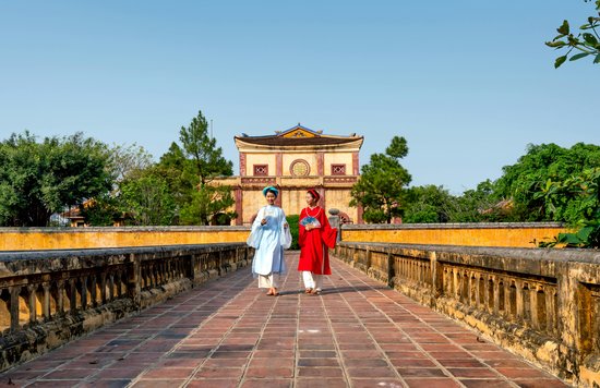 Women dressed in traditional clothes walking in Hue, Vietnam