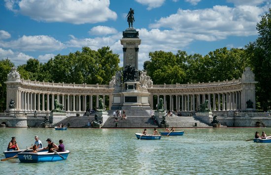 Rowboats on the lake at El Retiro Park, Madrid, with clear skies and trees | Photo Credit: Karabo Photo on Pexels