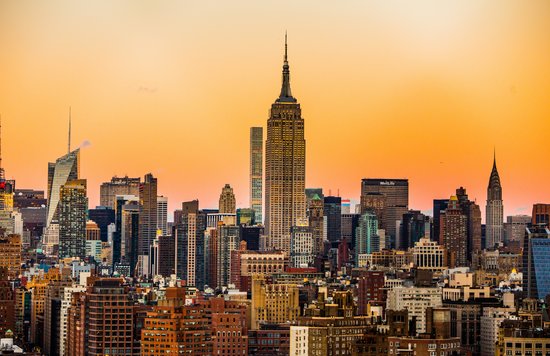 Skyscrapers and tall buildings against a bright orange sunset