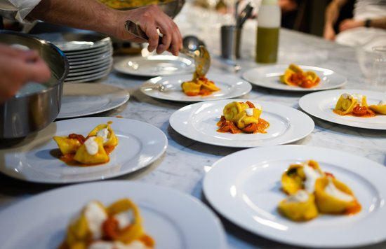 Fresh handmade pasta being plated during a cooking class in Florence