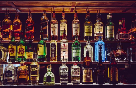 Bottles of whiskey, gin, and liqueur displayed at a Melbourne CBD bar shelf