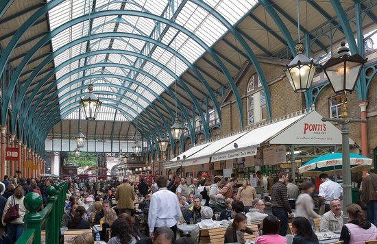 Busy Covent Garden Market with restaurants and people dining under a glass ceiling