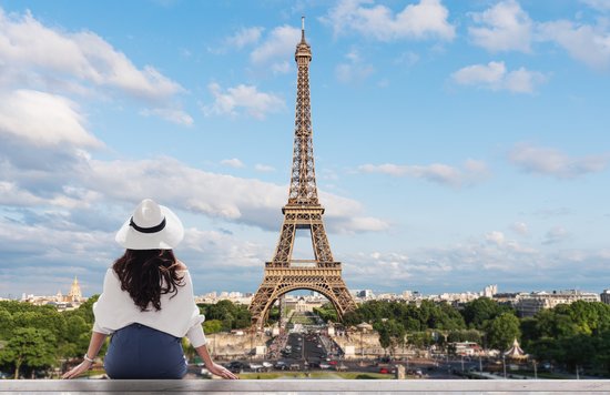 Woman overlooking Eiffel Tower view in Paris skyline at sunset