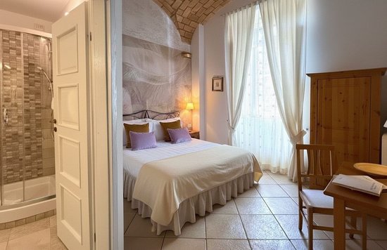 Relais Le Clarisse room with wooden beams in Trastevere, Rome