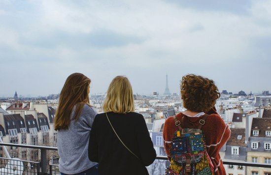 Three young women admiring a view of Paris from above.