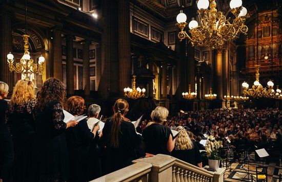 Musicians performing a classical music concert inside a grand, historic Paris church, illuminated by soft candlelight