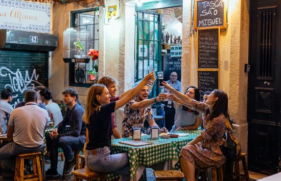 Friends sharing and toasting drinks in a bar in Seville | Photo Credit: Wikimedia Commons