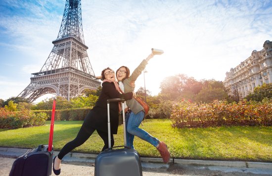 Two women posing in front of the Eiffel Tower in Paris