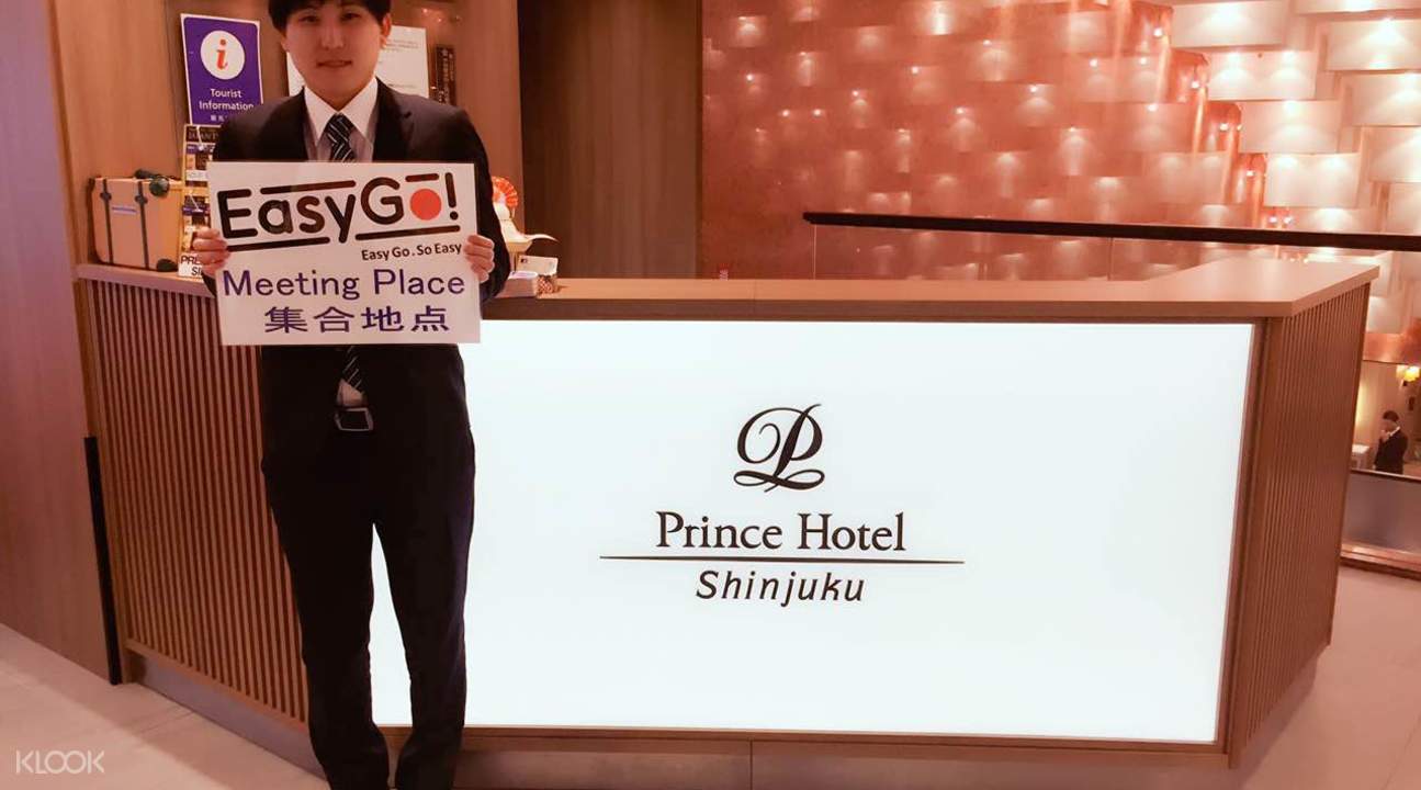 集合地點位於新宿王子飯店,服務人員拿著指示牌。