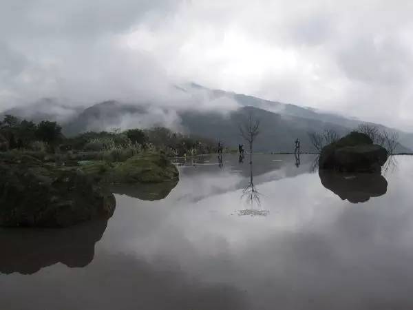 如 一 片 明 鏡 , 照 映 著 山 巒 與 雲 霧