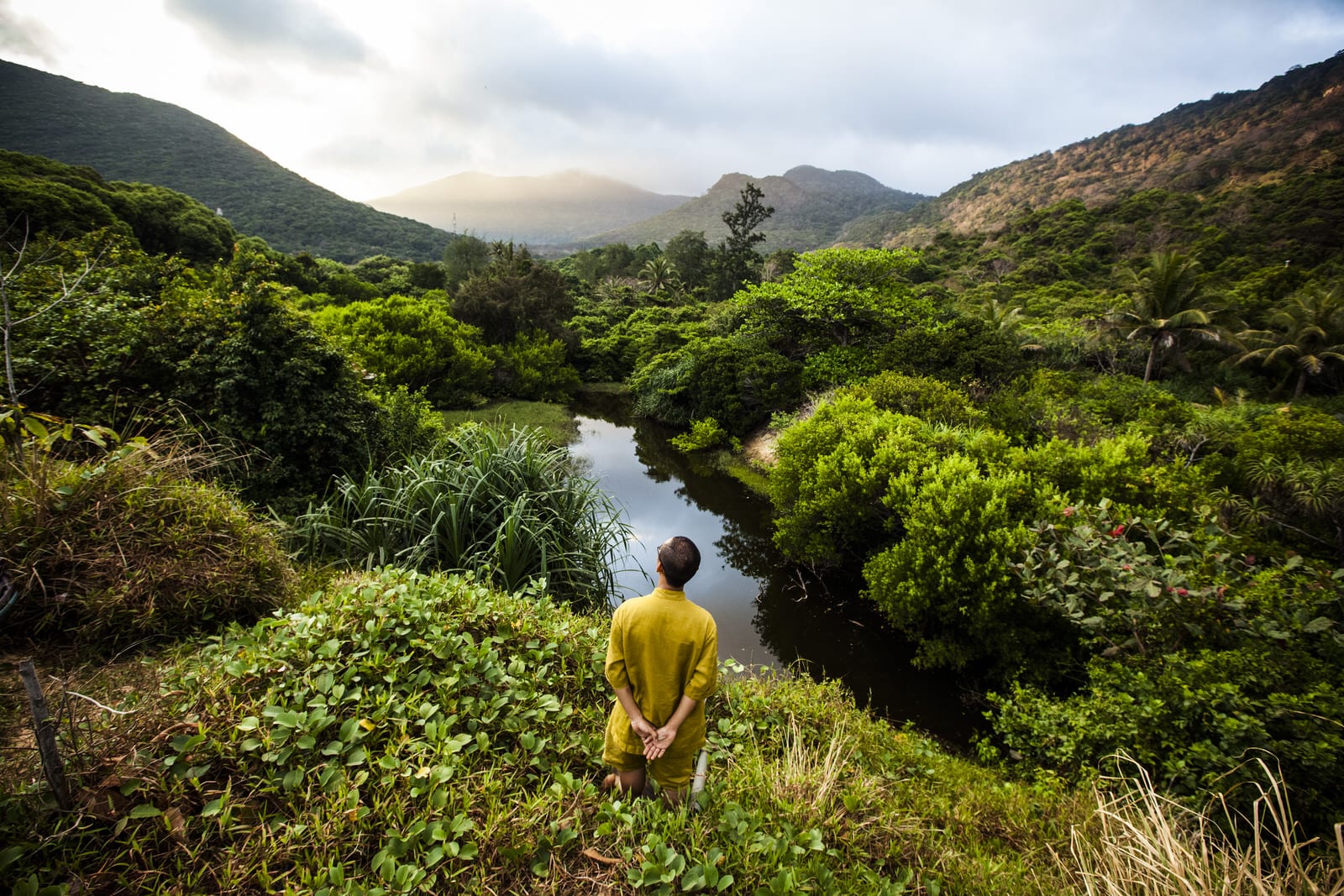 A butler at the Six Senses Con Dao resort in southern Vietnam overlooks a green, mountainous landscape off the resort's grounds. Once a secluded prison island, Con Dao is now turning into a luxury tourism destination.