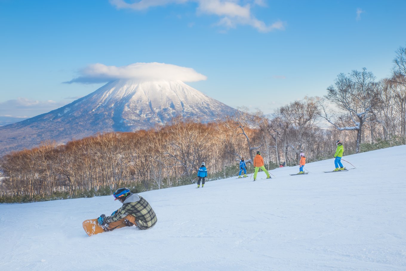 people skiing with mt yotei in the background