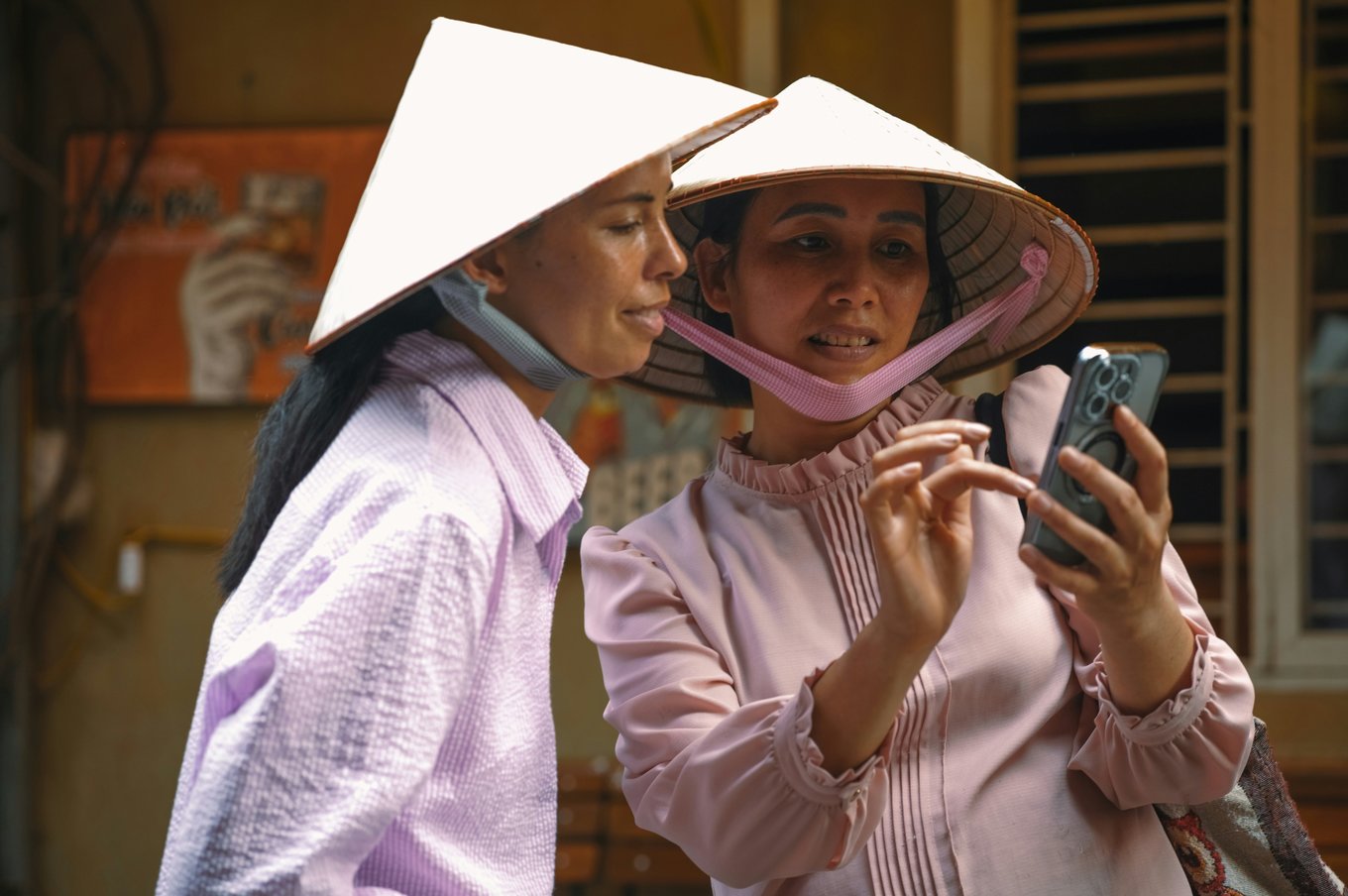 two Vietnamese people looking at a phone