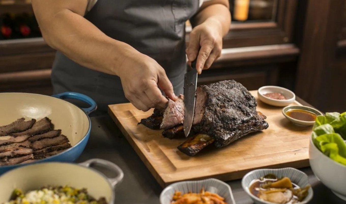 A person slicing steak