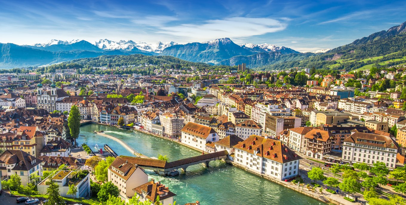 Panoramic view of Lucerne with Chapel Bridge and Alps behind the city