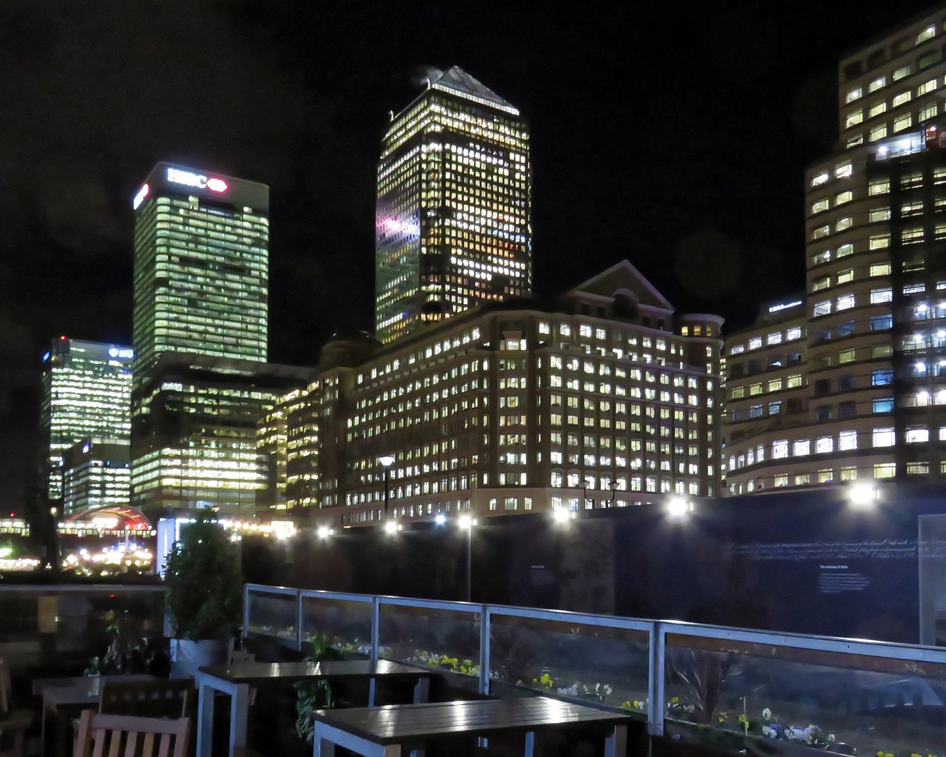 Night skyline view from a rooftop bar in the UK with illuminated buildings