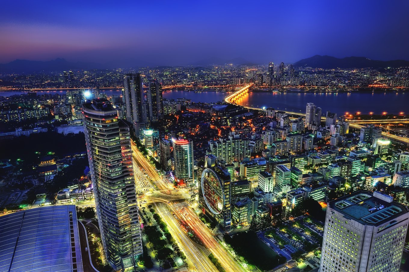 Night view of Seoul city skyline with illuminated buildings and river