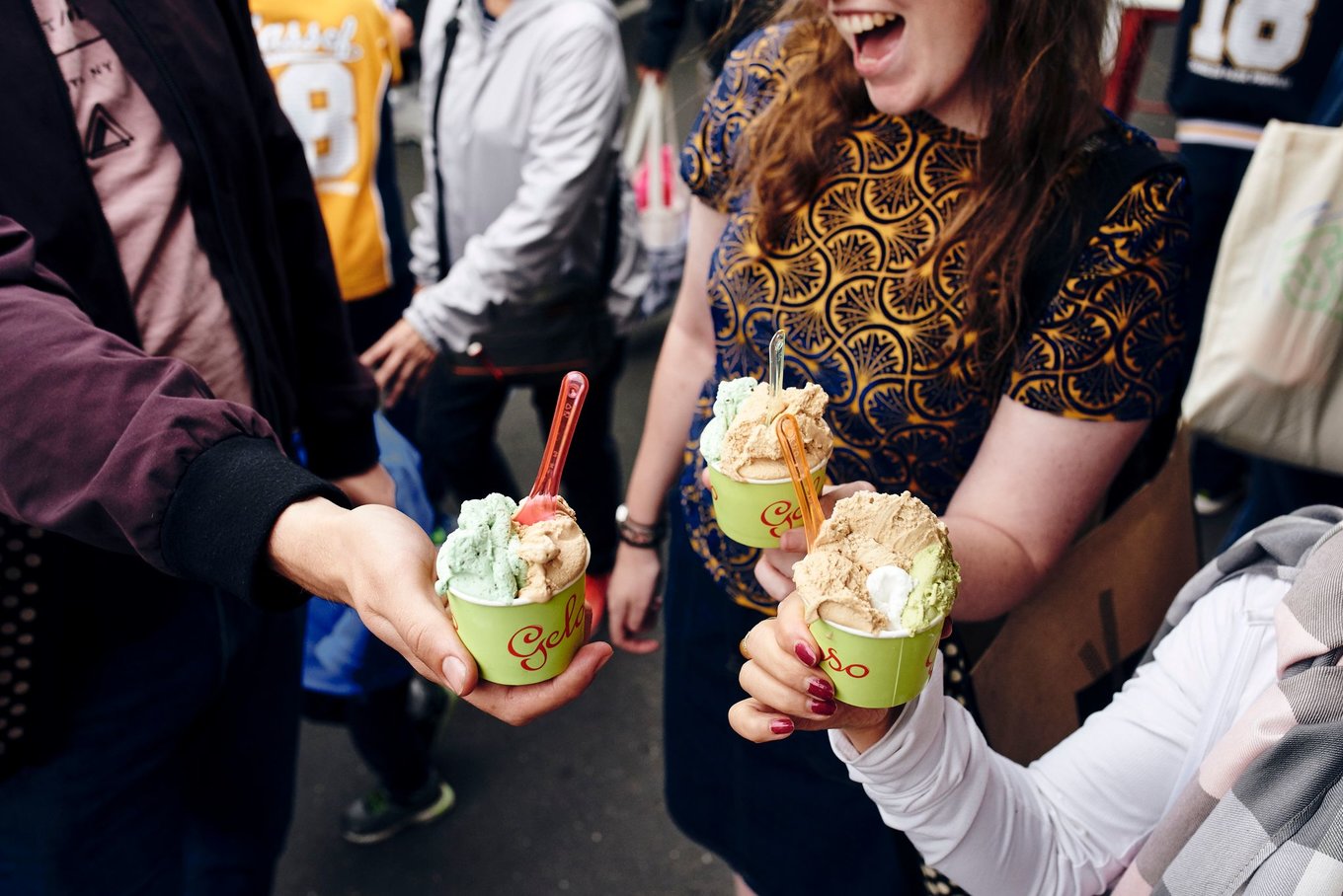People holding cups of gelato while exploring Melbourne streets
