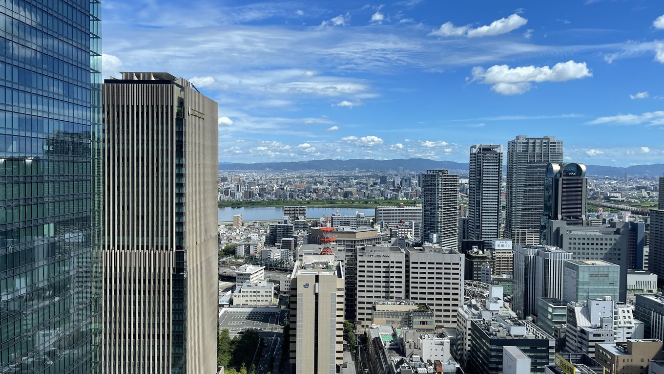Osaka skyline view showing city buildings and river under blue sky
