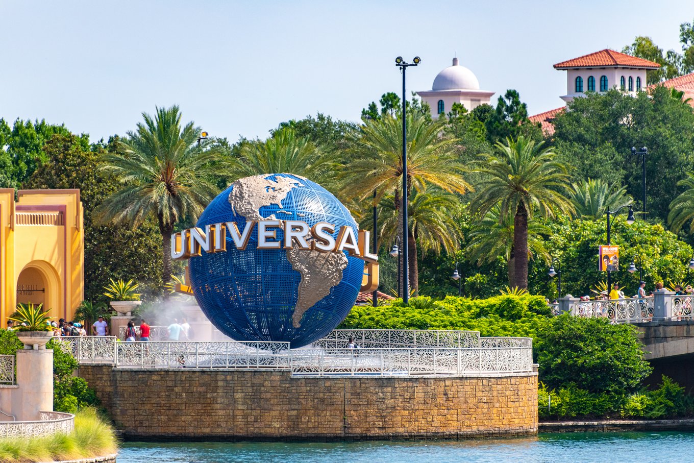 The iconic Universal globe welcomes visitors to Universal Studios Orlando, surrounded by palm trees and park entrances