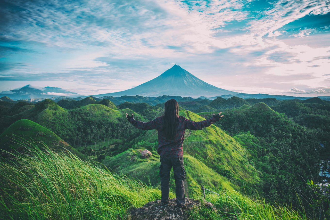 Solo traveler standing on a hilltop, embracing freedom and calm during an introverted solo journey | Photo from Archie Binamira on Pexels
