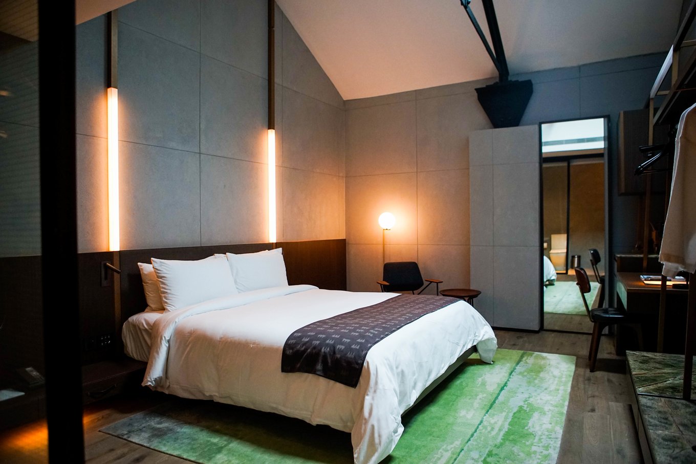 Modern hotel room with a neatly made bed, soft lighting, and minimalist design - clean, comfortable, and hassle-free.