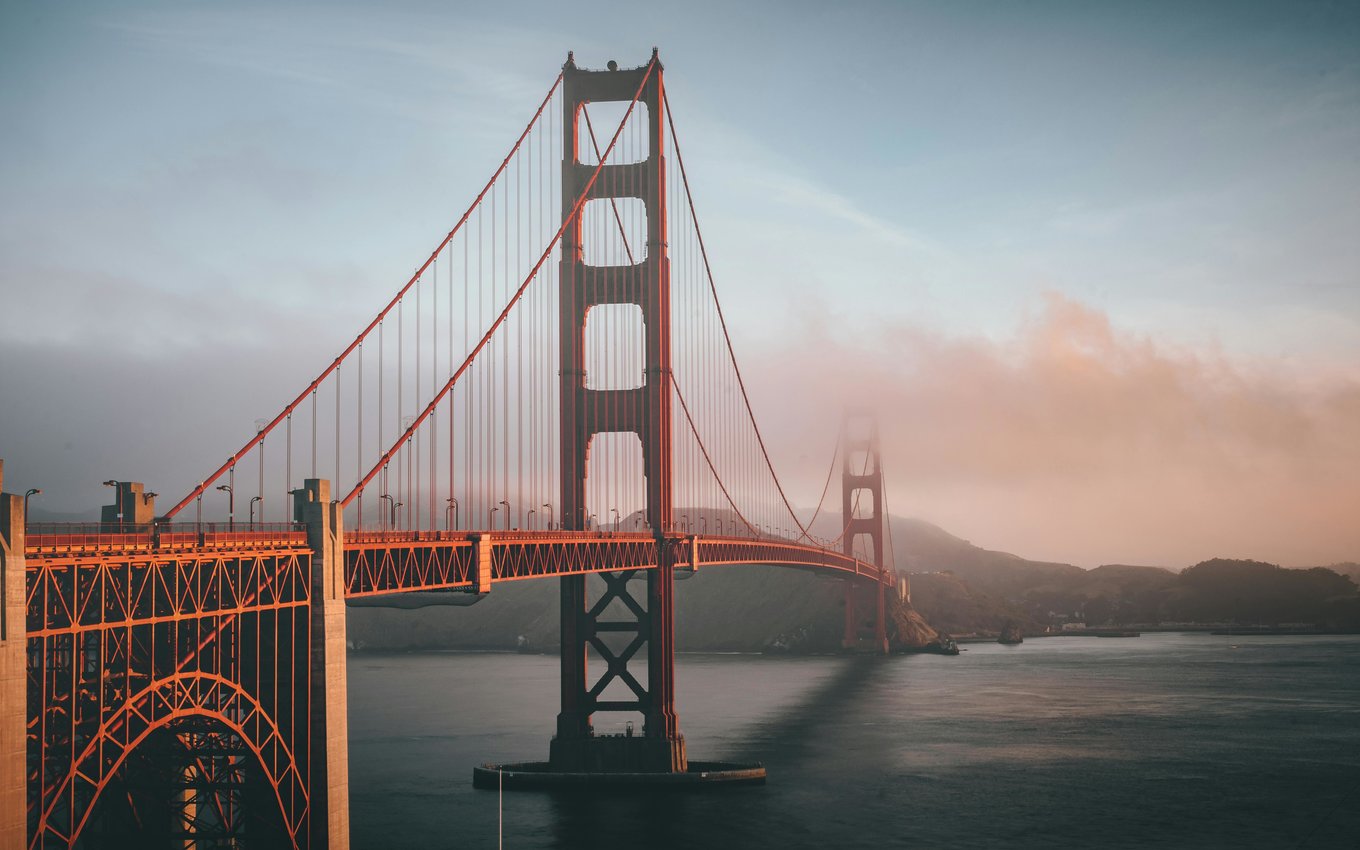 Golden Gate Bridge in San Francisco stretching over water with light fog