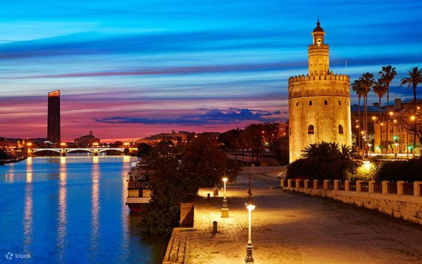 Torre del Oro and Guadalquivir River at sunset in Seville with colorful evening sky.