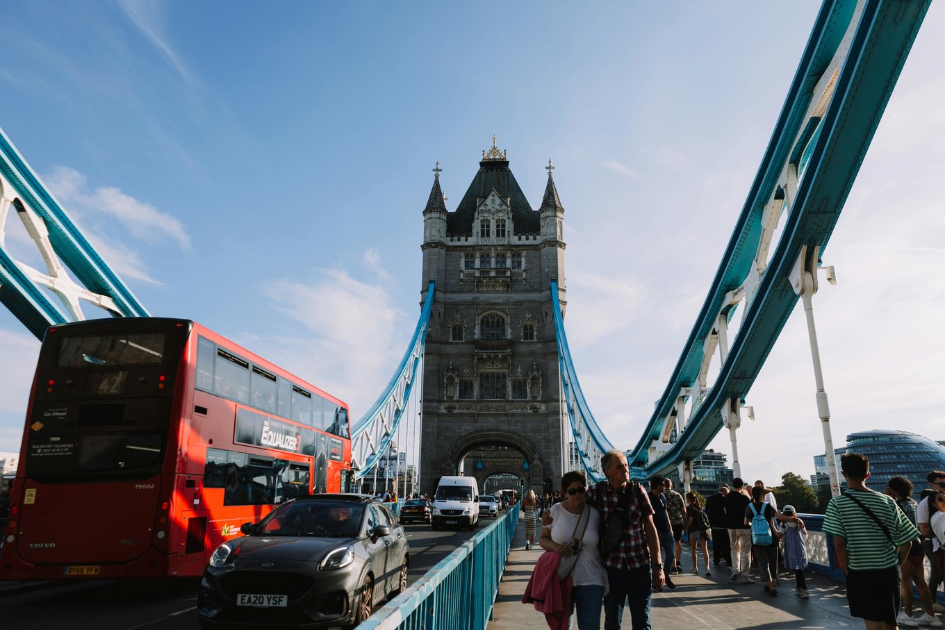 Pedestrians and traffic crossing Tower Bridge in London on a sunny day