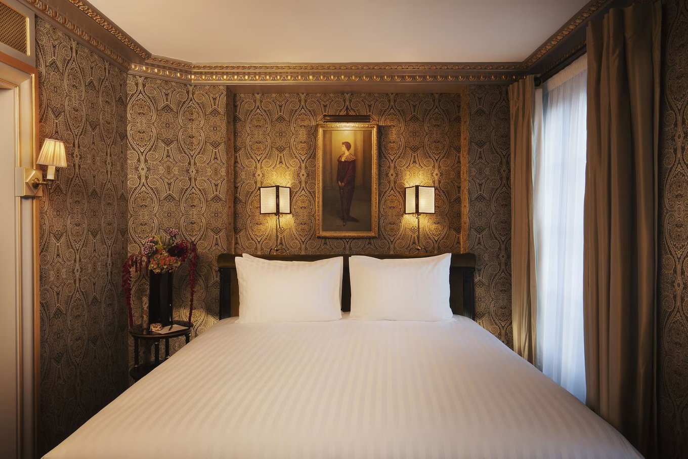 Luxury bedroom at Maison Proust Hotel inspired by Marcel Proust with elegant fabrics and artwork.